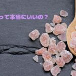 ピンク塩の粒とスプーンを写した写真